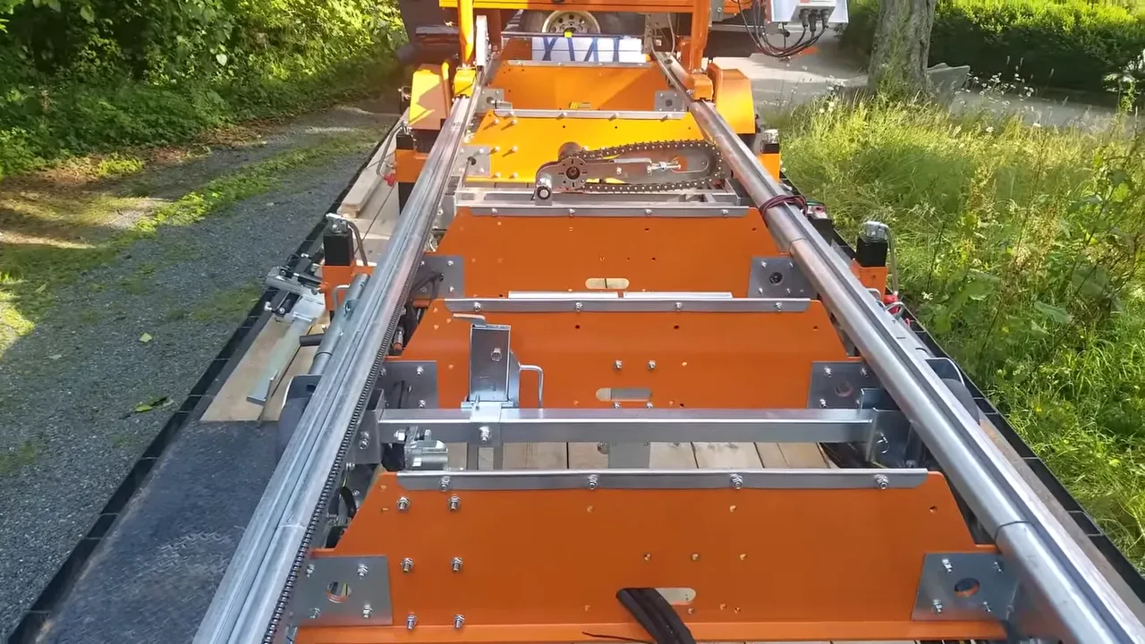 Norwood sawmill loaded on trailer with rails, mounts, chain and straps visible