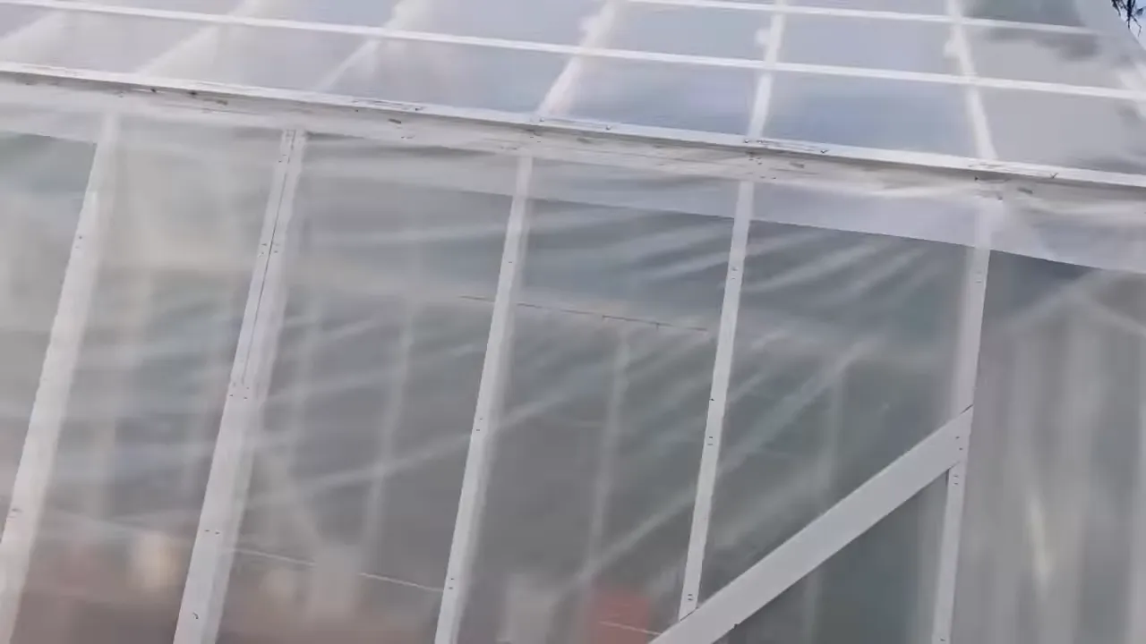 Close-up of greenhouse plastic cladding and roof-mounted solar panel