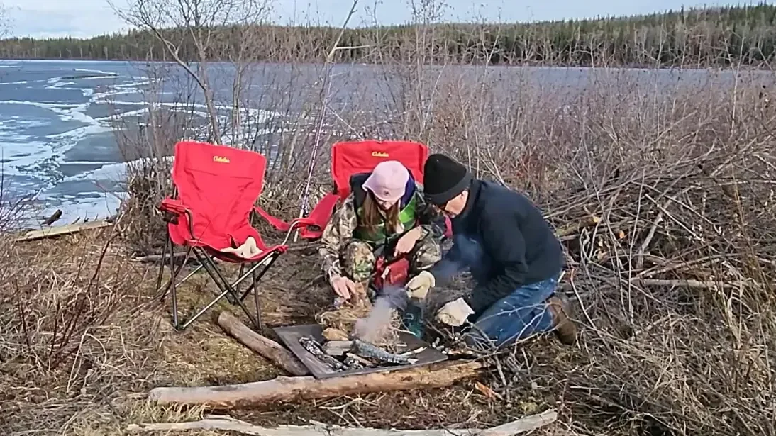 Attempting to start a fire with flint.