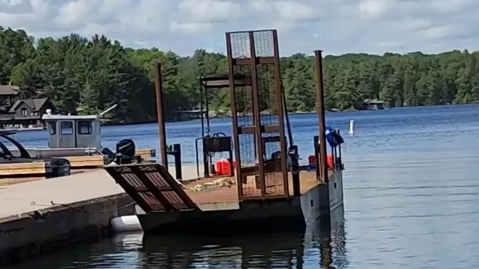 A barge is docked beside a dock in a marina
