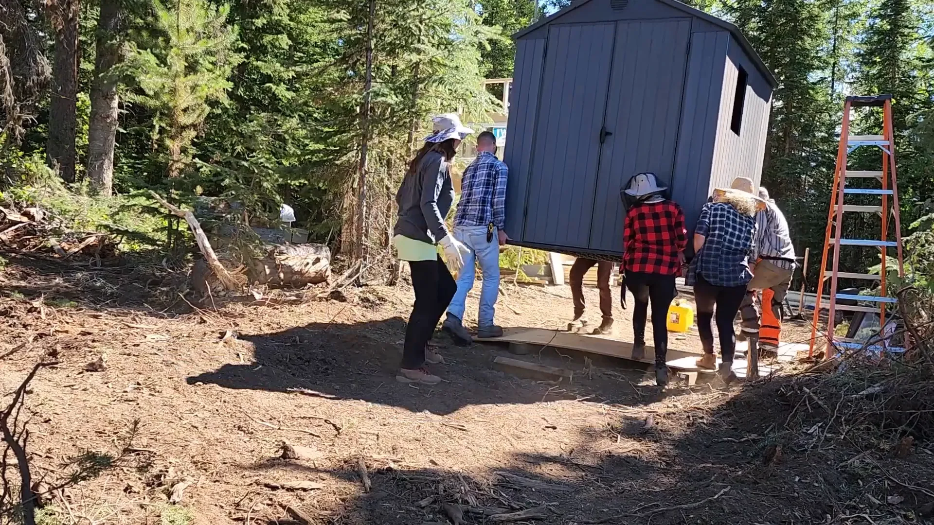 Woman operates heavy equipment - moving a shed