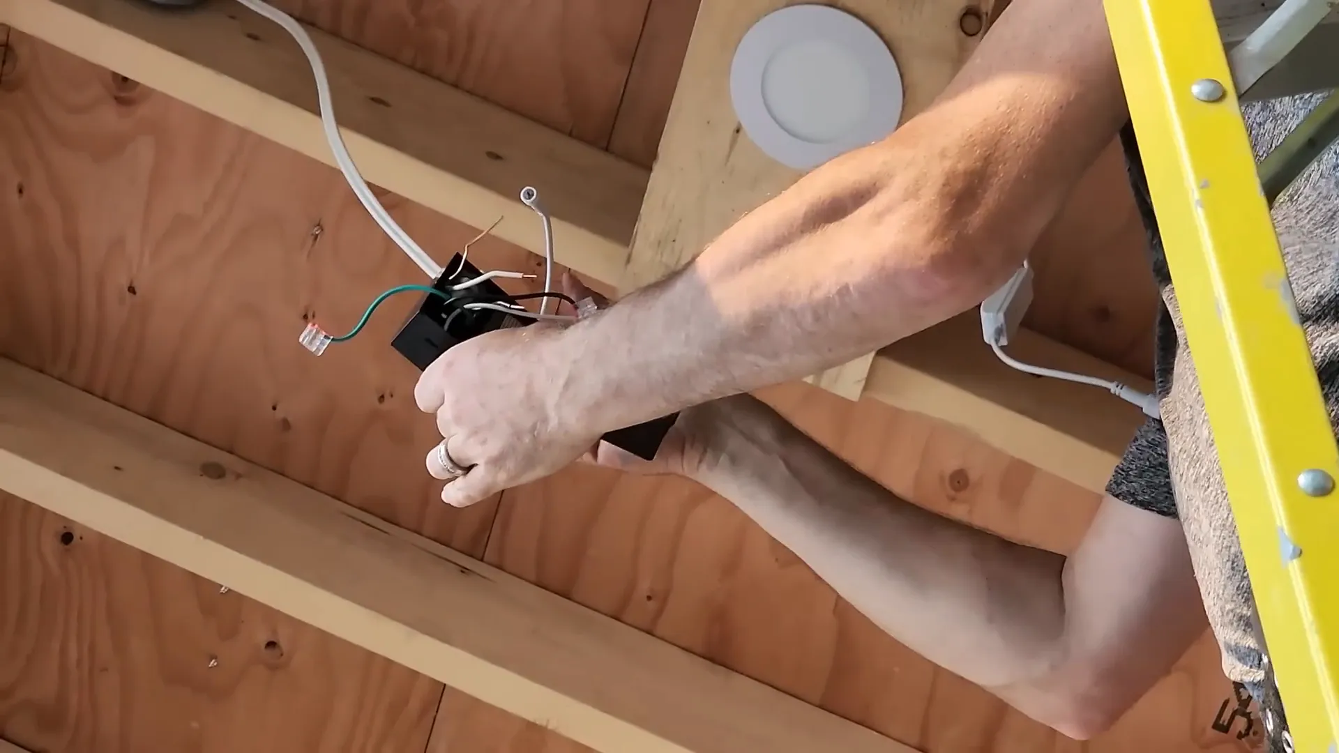 A man installs ceiling lighting