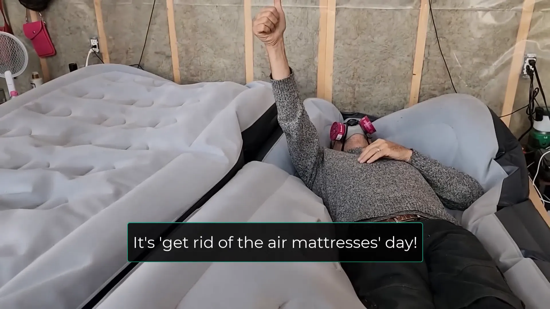 A man on an deflating air mattress wearing a gas mask