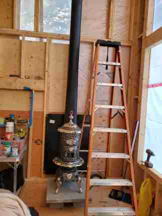 Inside a tiny cabin with a small antique ornate wood stove