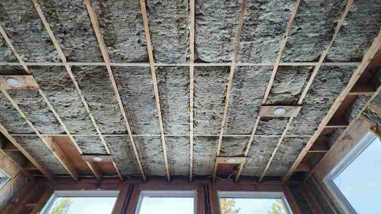 A tall sloped ceiling under construction, showing lighting and insulation