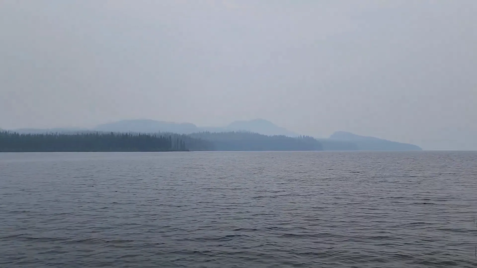 A view across a body of water is cutoff by thick smoke