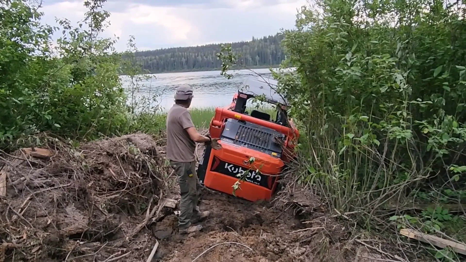 This is Our Toughest Task So Far - Will We Succeed? - S2 Ep26 4 Our toughest task so far - a man looks at his track loader as it is sinking into the mud on the shore of a lake