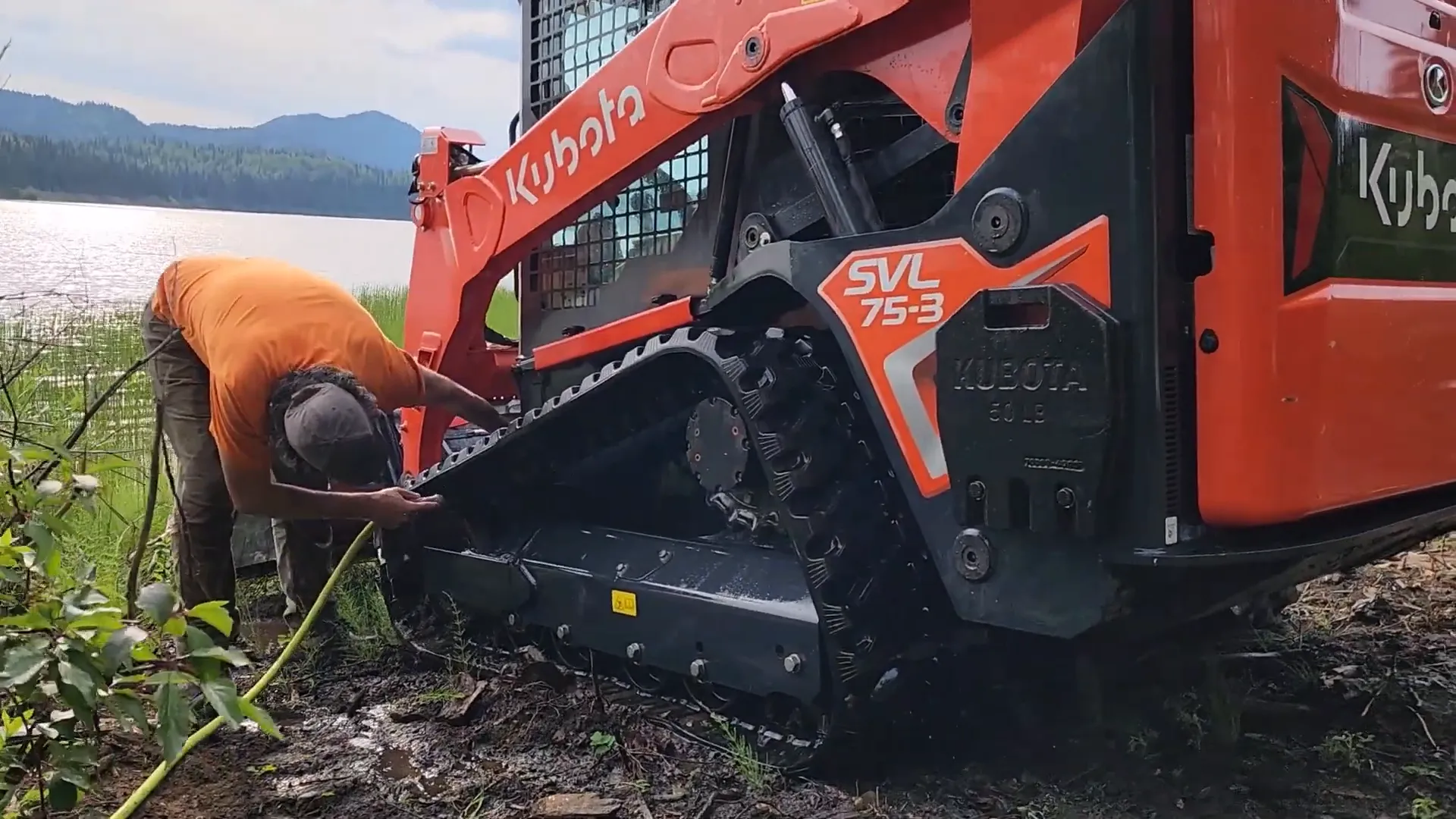 Is Our Toughest Task Too Tough? - S2 Ep27 6 A man washes his kubota track loader beside a lake