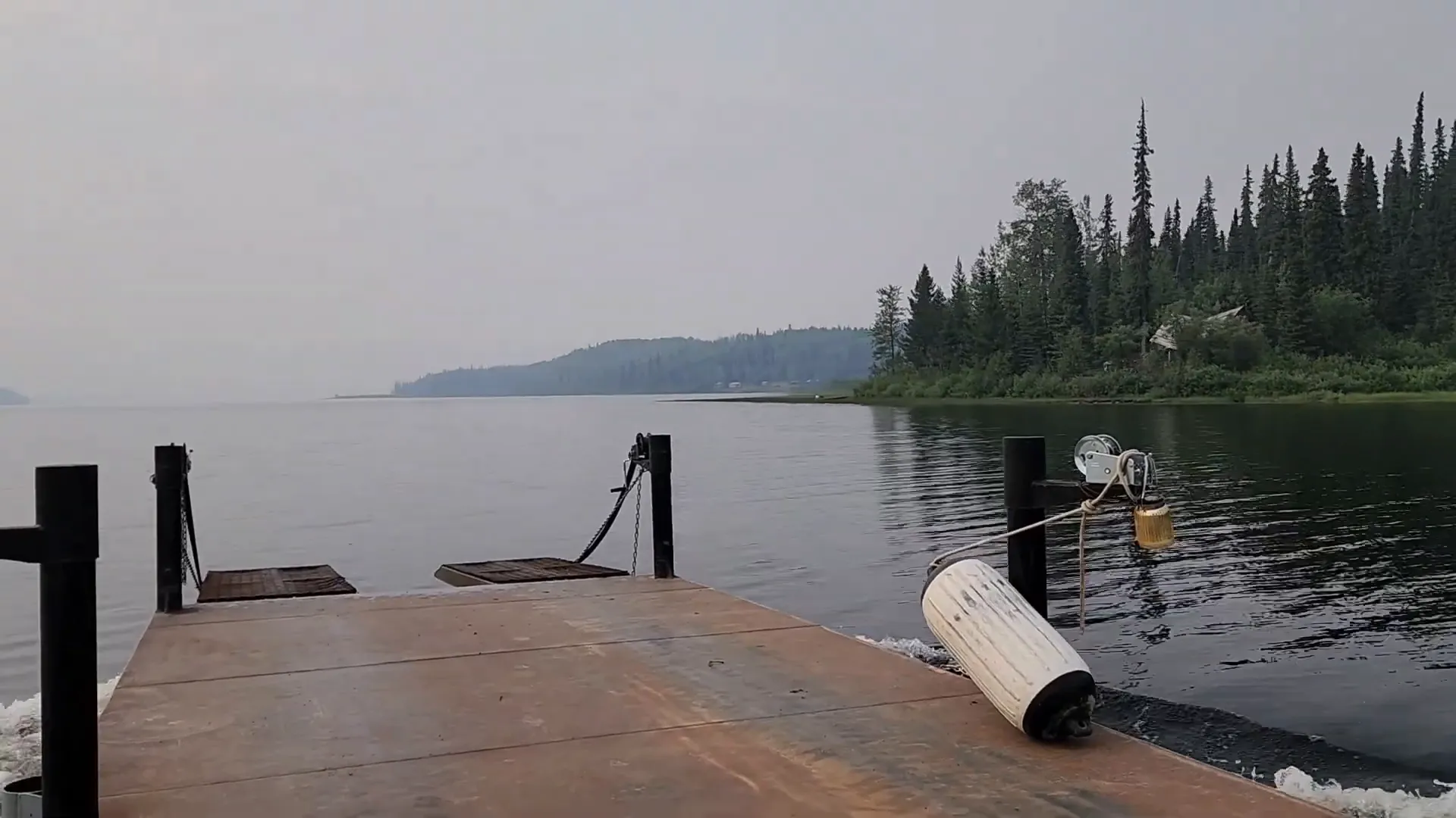 A barge sails beside an island in thick smoke