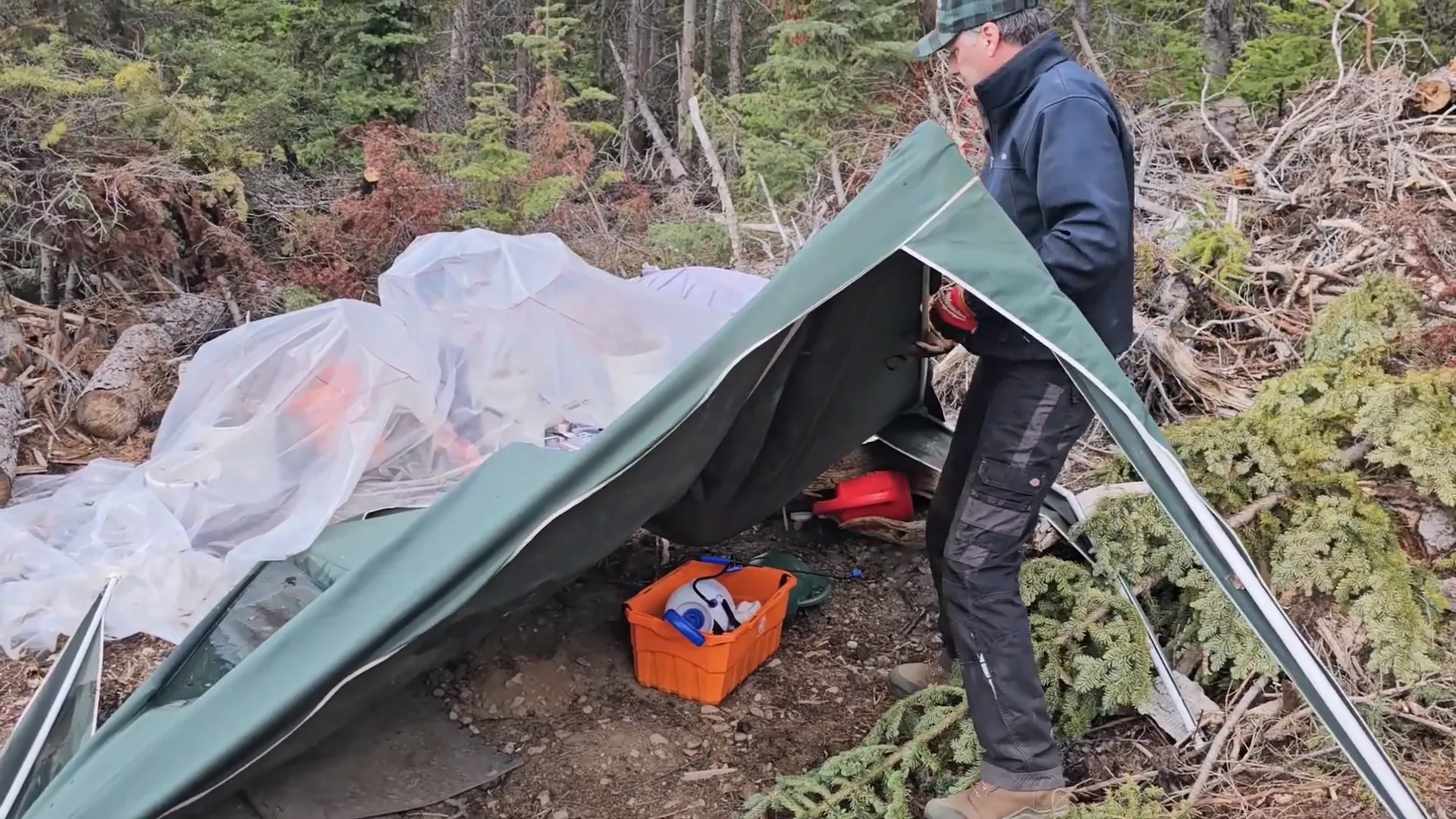 Off-Grid Island Winter Damage: What’s Still Standing? | S3 Ep2 3 A man struggles with a mangled canvas shelter on an off-grid island homestead