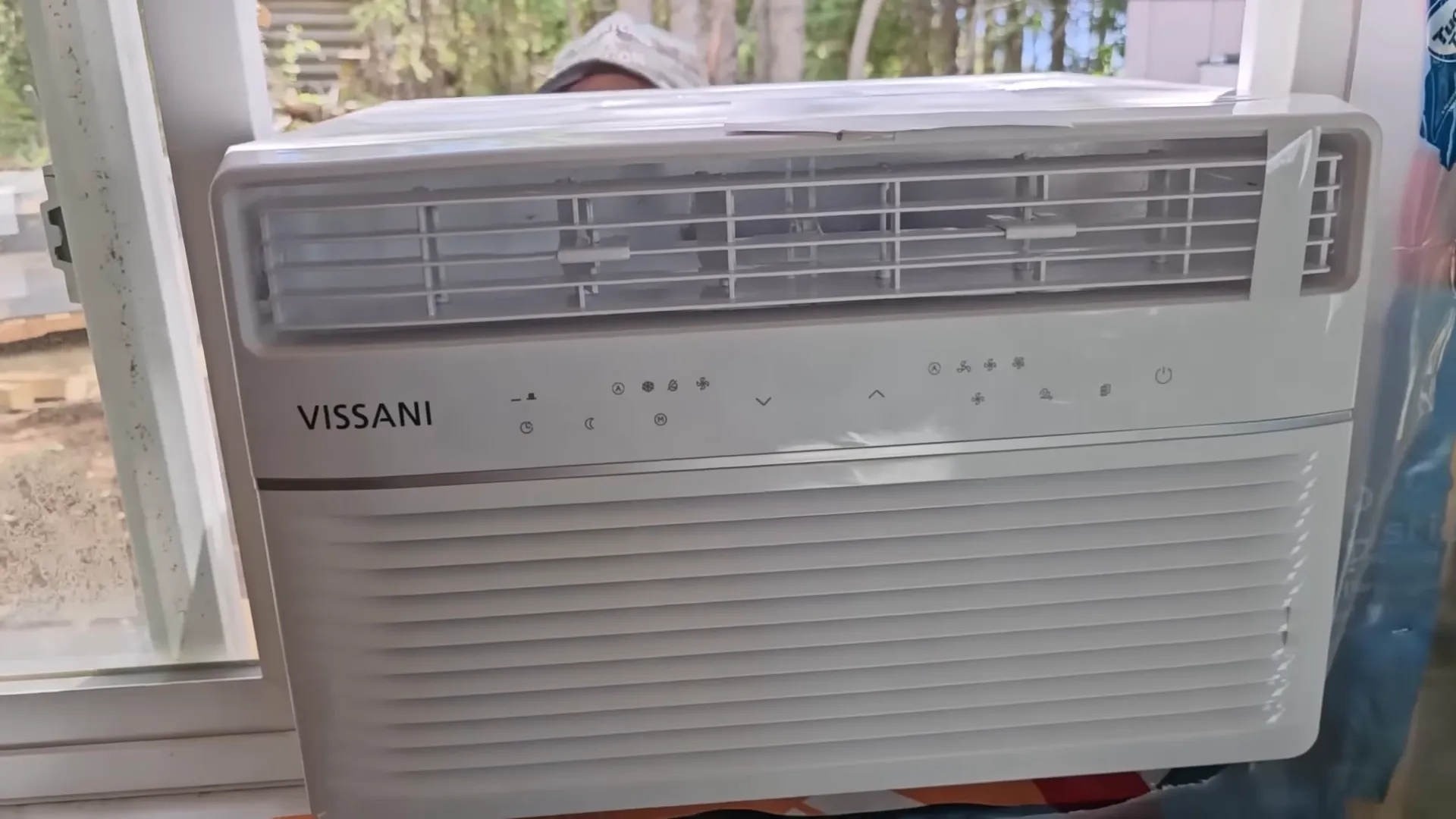 Remote island living - air conditioner being fitted into a horizontal slider window