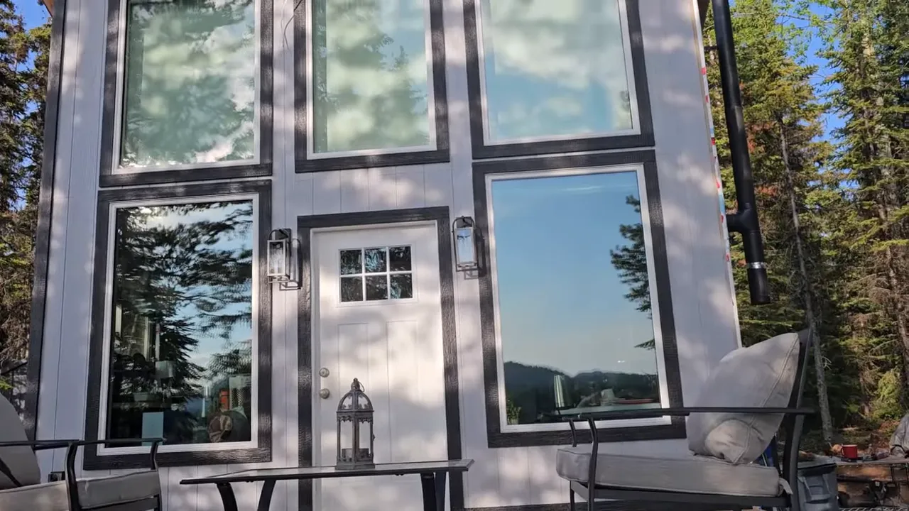 Off Grid Cabin Build: Facing Fears on Homemade Scaffolding After My Bad Fall | S4 Ep9 3 Full cabin front showing finished corner cap and contrasting dark trim around windows and door