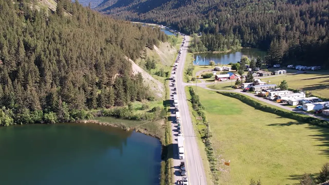 One Slip and Our New Sawmill Falls Into the Water! - S4 Ep11 2 Wide drone aerial showing a long queue of vehicles along highway 97 beside a lake and campground, clear and detailed.