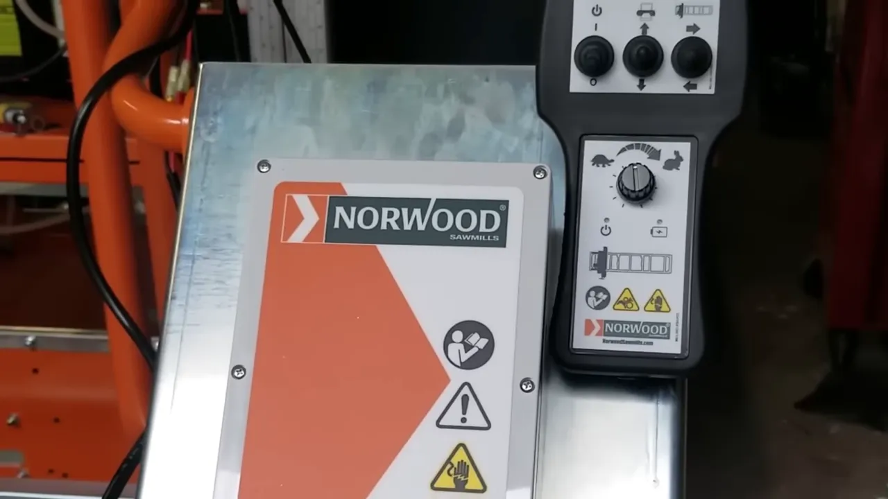 Clear view of norwood sawmill control panel and handheld remote featuring control knobs, buttons and the norwood logo.