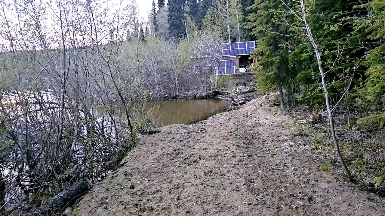Melodi standing on the edge where the bank has caved in
