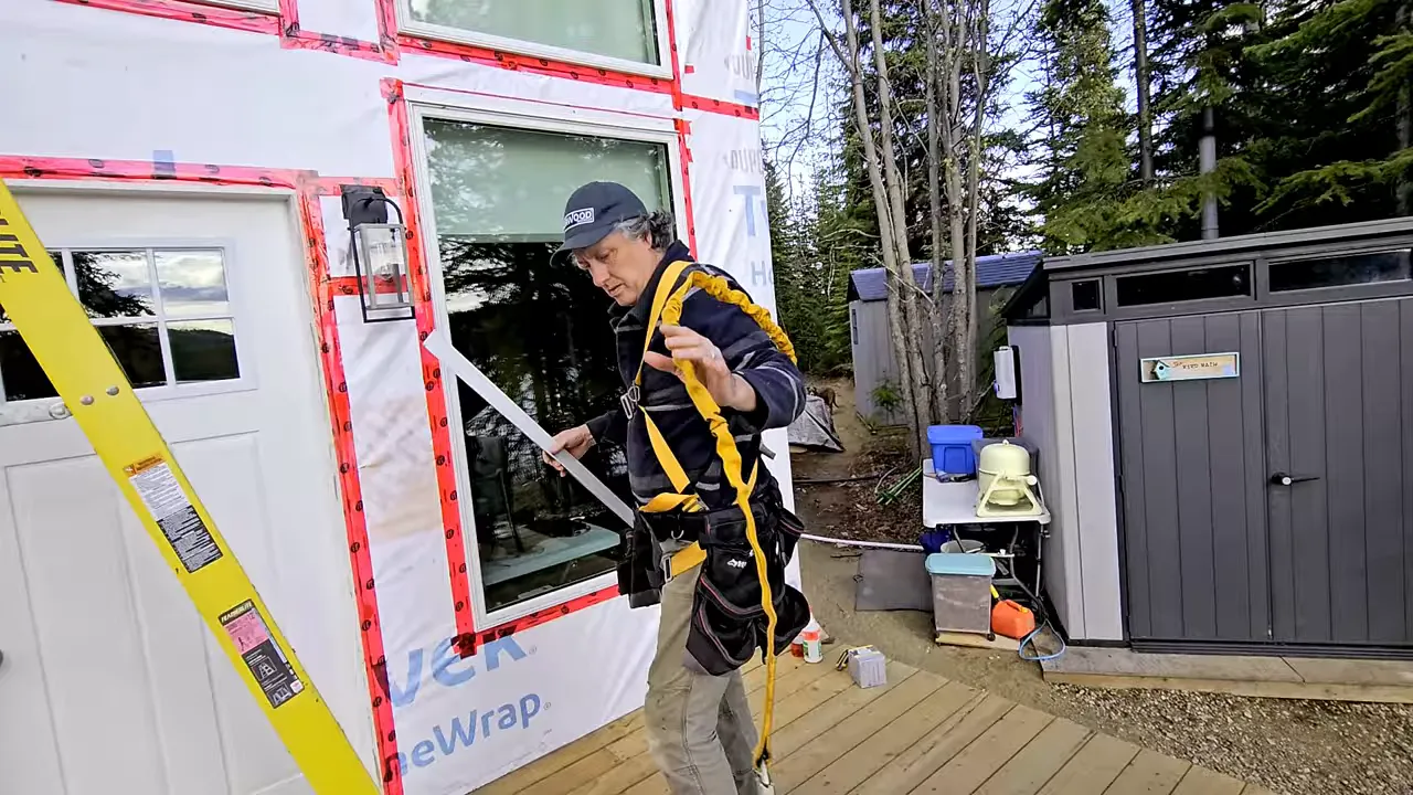 Ryan preparing for higher work, checking ladder and fall protection gear