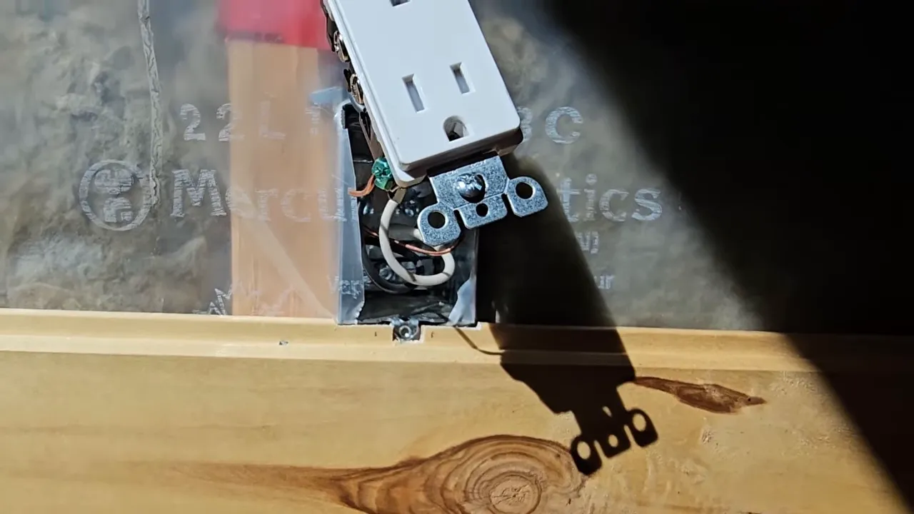 Electrical box and wiring installed in an off-grid tiny cabin wall cavity with surrounding insulation