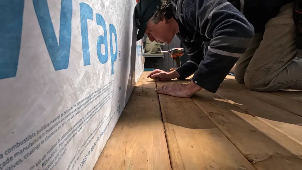 Applying butyl tape around ledger board where water needs to shed