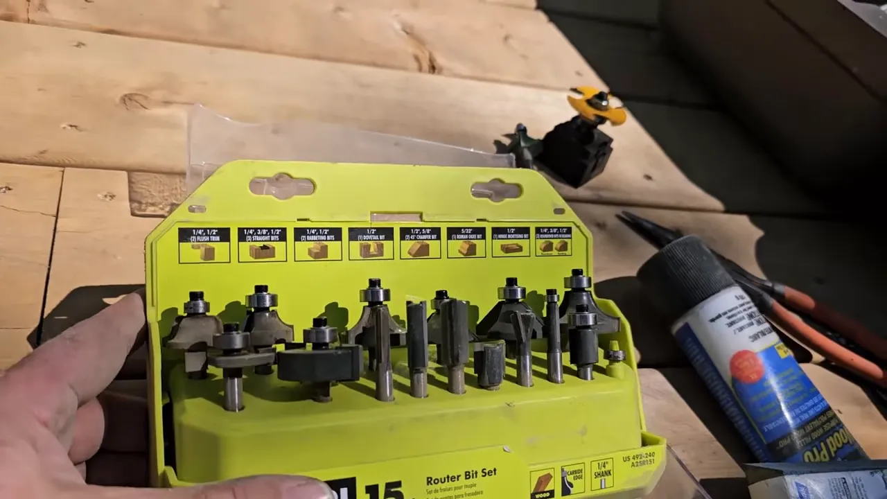 Off Grid Life Canada: Building a Tiny Cabin on Our Remote Island – Biggest Transformation Yet! - S4 Ep8 3 Close-up of a yellow router bit set case showing multiple router bits and rabbeting cutters on a wooden work surface.